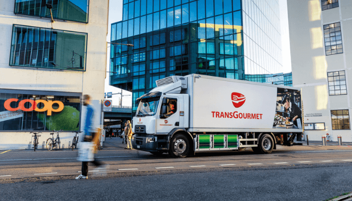 Un camion Transgourmet devant un magasin Coop en Suisse