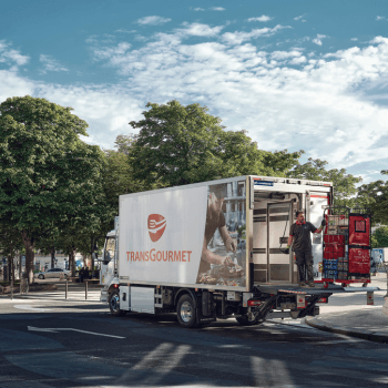 Un chauffeur-livreur avec un roll sur le hayon d'un camion Transgourmet