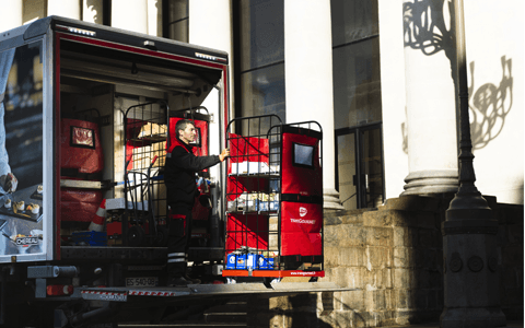 Un chauffeur-livreur avec un roll sur le hayon d'un camion Transgourmet