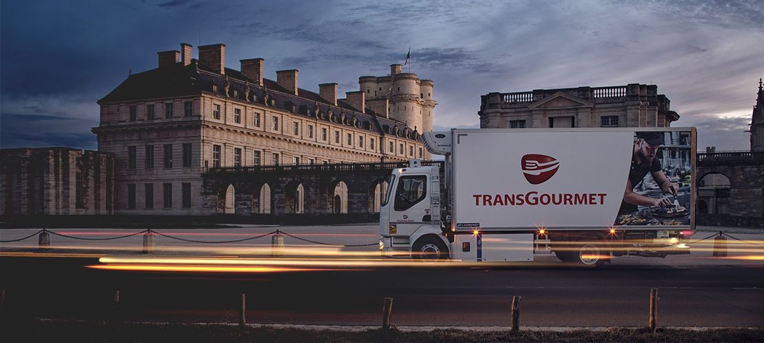 Un camion Transgourmet, de nuit, devant le château de Vincennes